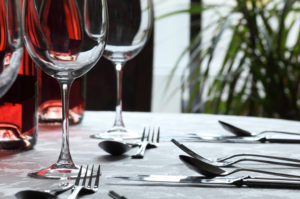 Restaurant table with silverware, wine and wine glasses